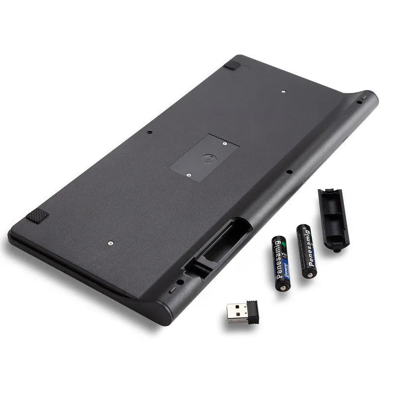 Black and white wireless keyboard and mouse set with USB receiver on a wooden desk.