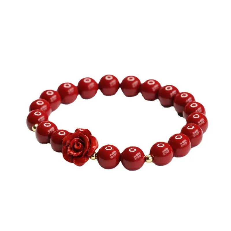 Close-up of a women's natural cinnabar bracelet with a detailed 8mm purple gold sand rose centrepiece.