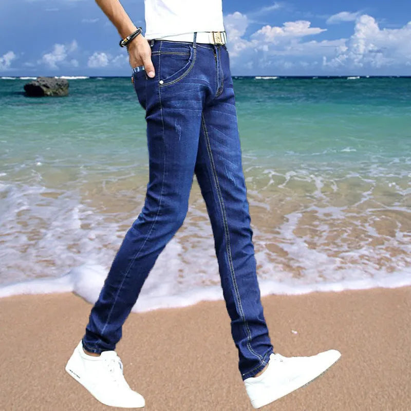 Thin men's loose skinny casual jeans in pure black with low waist, cropped leg, small leg opening, and zip fly.