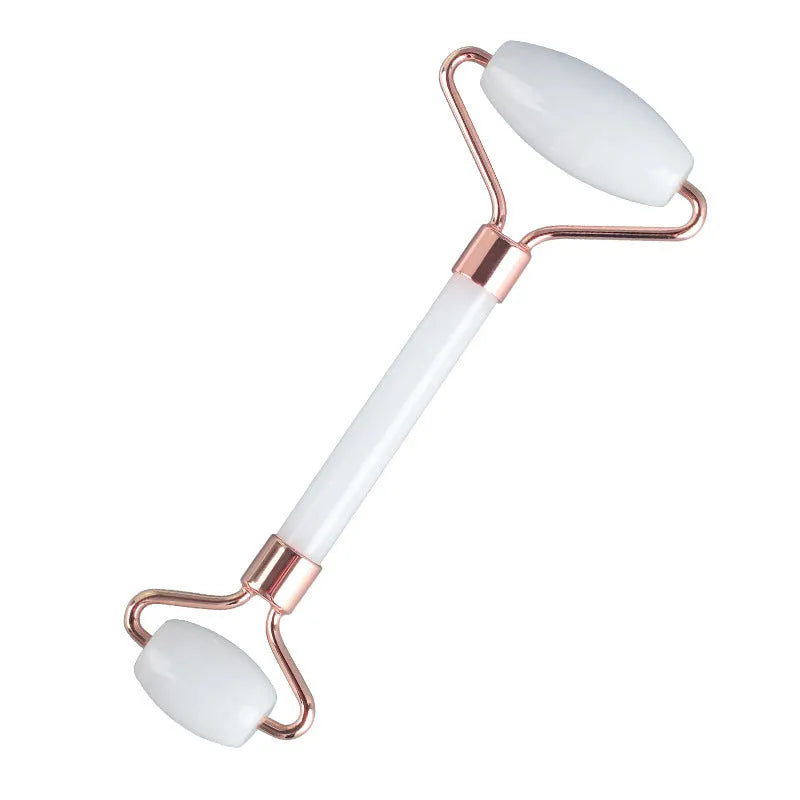 White jade facial roller set with double-headed roller claw and scraping board on wooden surface
