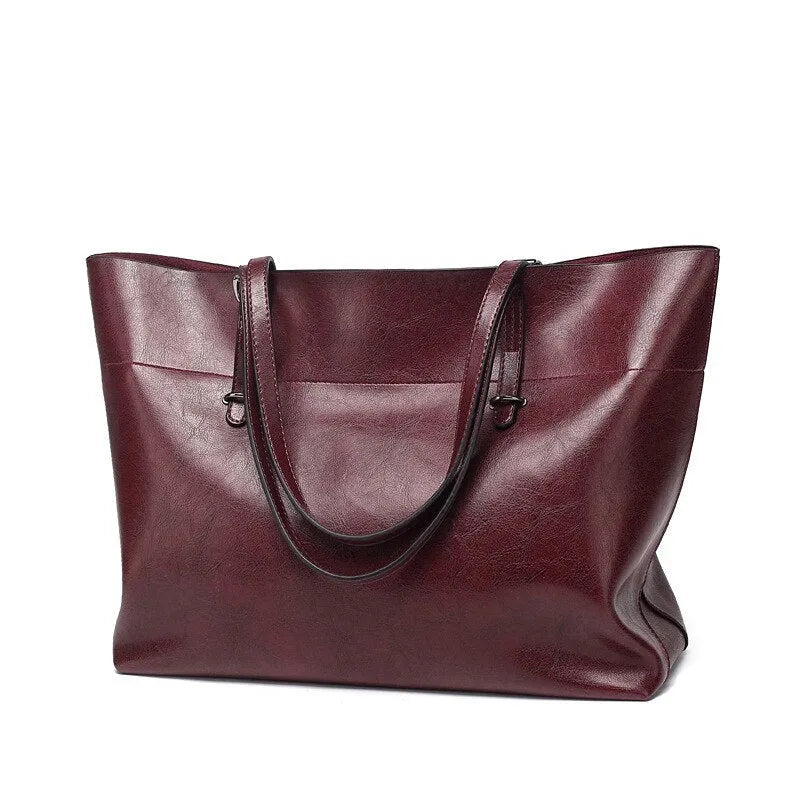 Brown leather cross-body handbag with a horizontal design showing two main compartments and a long strap.