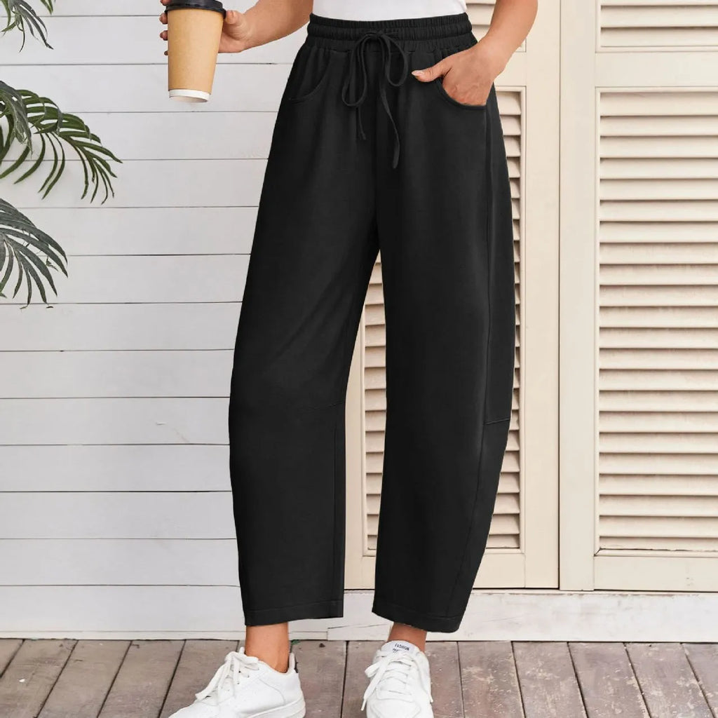 Women's loose cropped sweatpants with elastic drawstring waist in apricot colour showing side pockets and street fashion styling