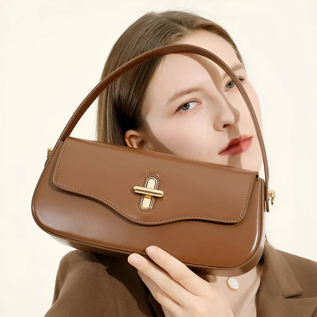Genuine leather baguette handbag in caramel colour with clamshell design and shoulder straps