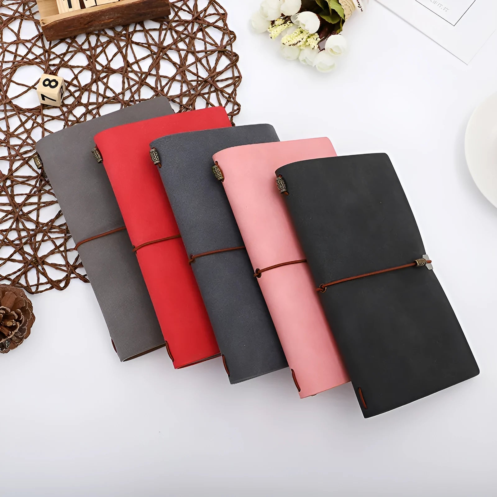 A6 notebook with imitation leather cover in grey, pink or red colours showing cowhide rope binding