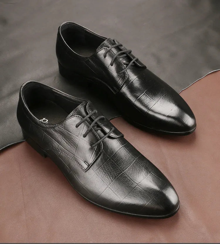 Men's black leather derby shoes with pointed toe and rubber sole on a white background.