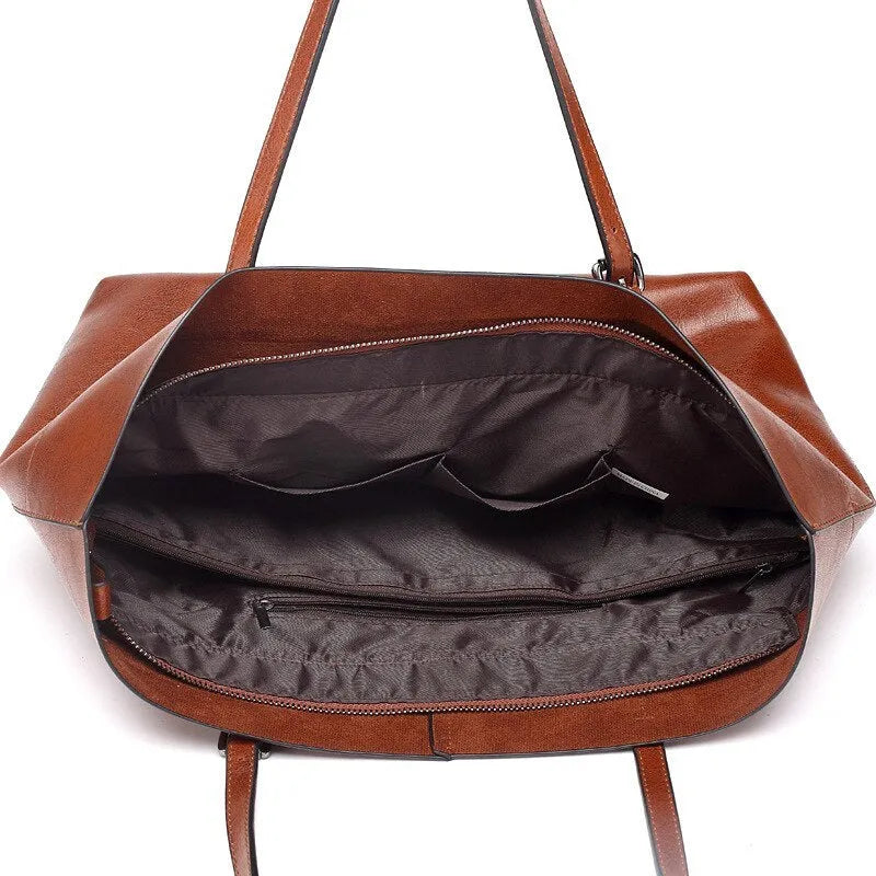 Brown leather cross-body handbag with a horizontal design showing two main compartments and a long strap.