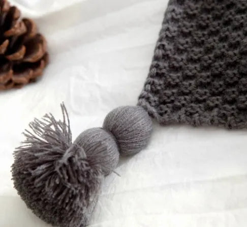 Nordic fringed knit ball acrylic blanket in beige colour, measuring 130 by 170 centimetres.