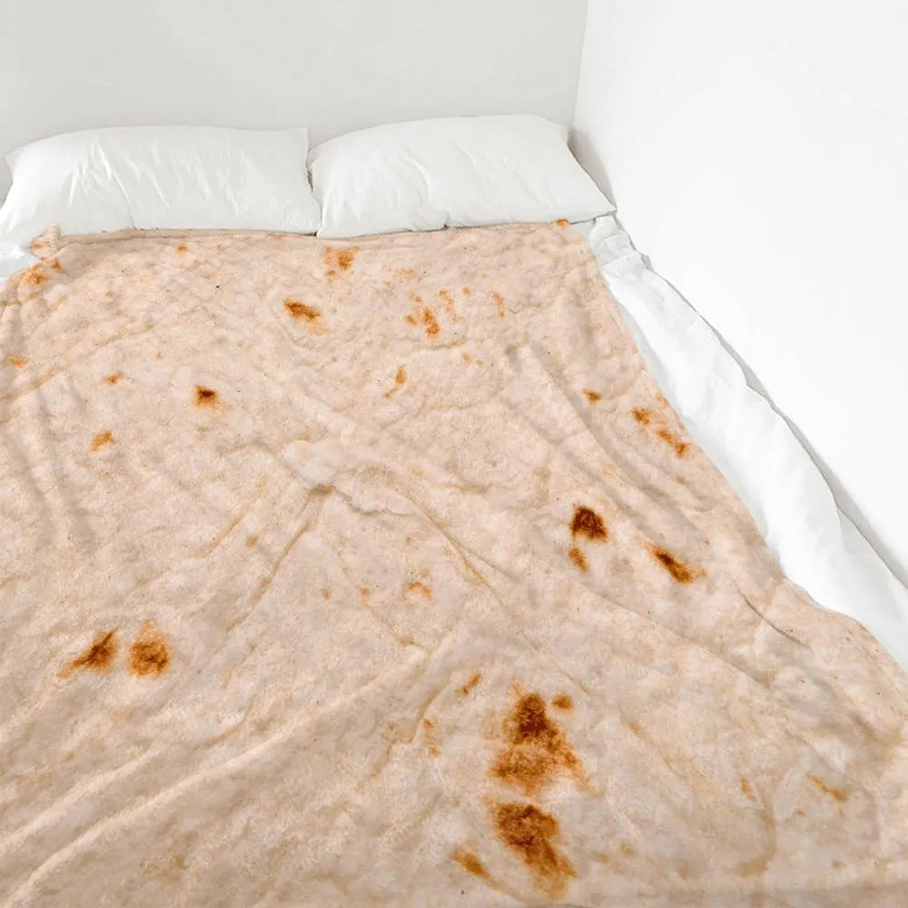Round coral fleece burrito blanket with food print, shown in a folded pile.