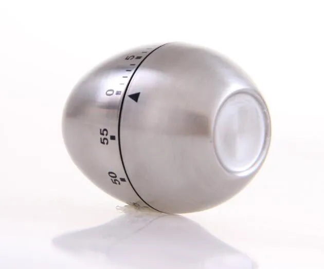 Egg-shaped stainless steel mechanical kitchen timer on a kitchen countertop.