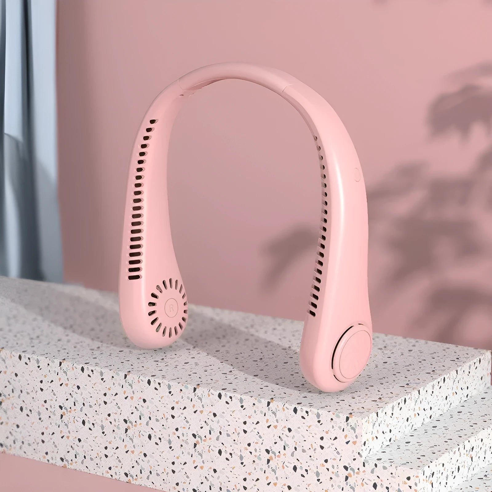 Pink USB rechargeable bladeless neck fan being worn, showing its adjustable speed controls and flexible neckband.