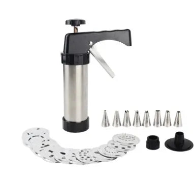 Stainless steel biscuit press gun with set of cookie moulds and piping nozzles on baking tray