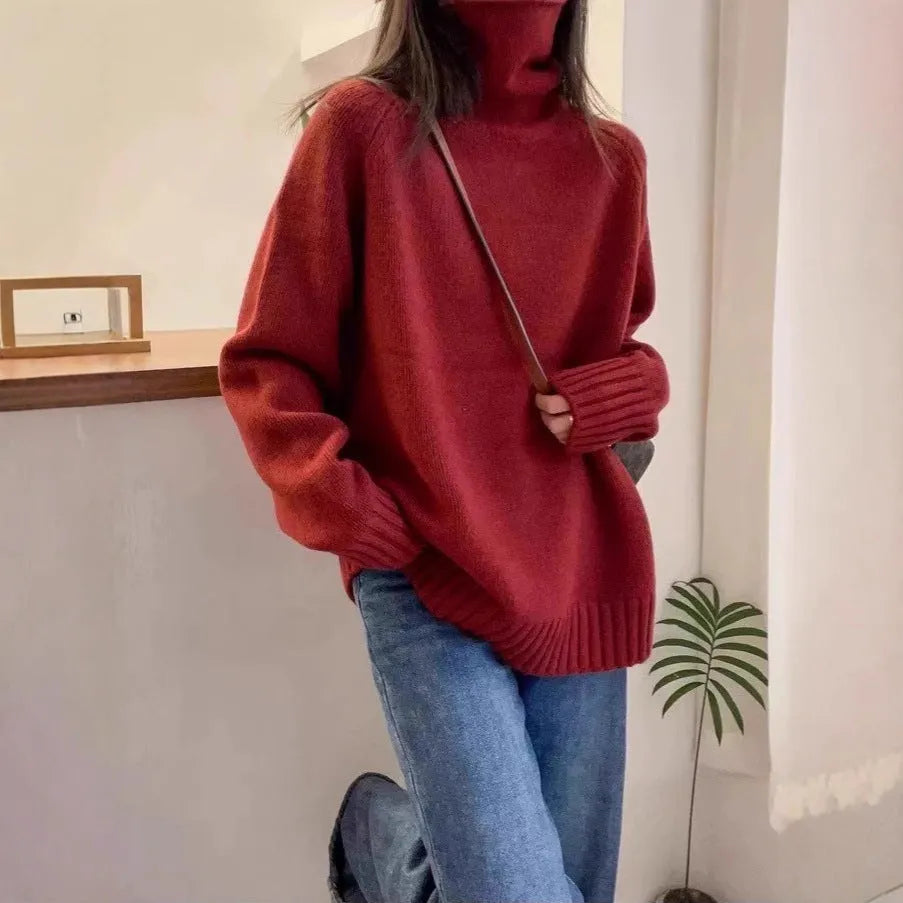 A woman wearing a loose red turtleneck sweater with a thick, curling pile collar.