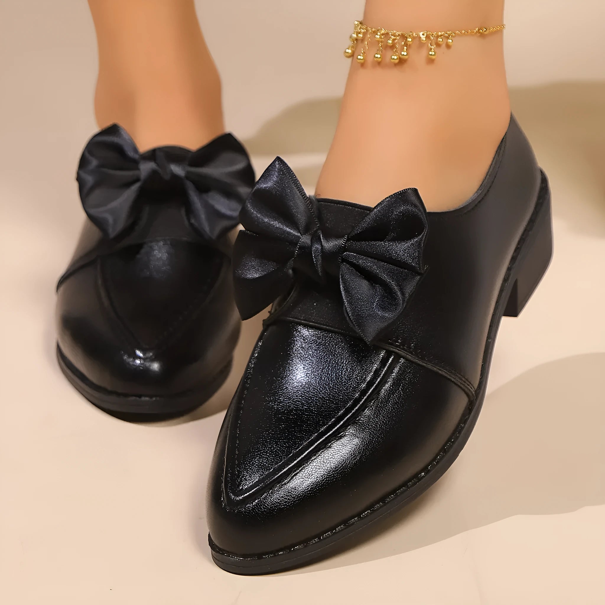 Women's pointed-toe PU slip-on shoe with a decorative bow on a rubber sole.