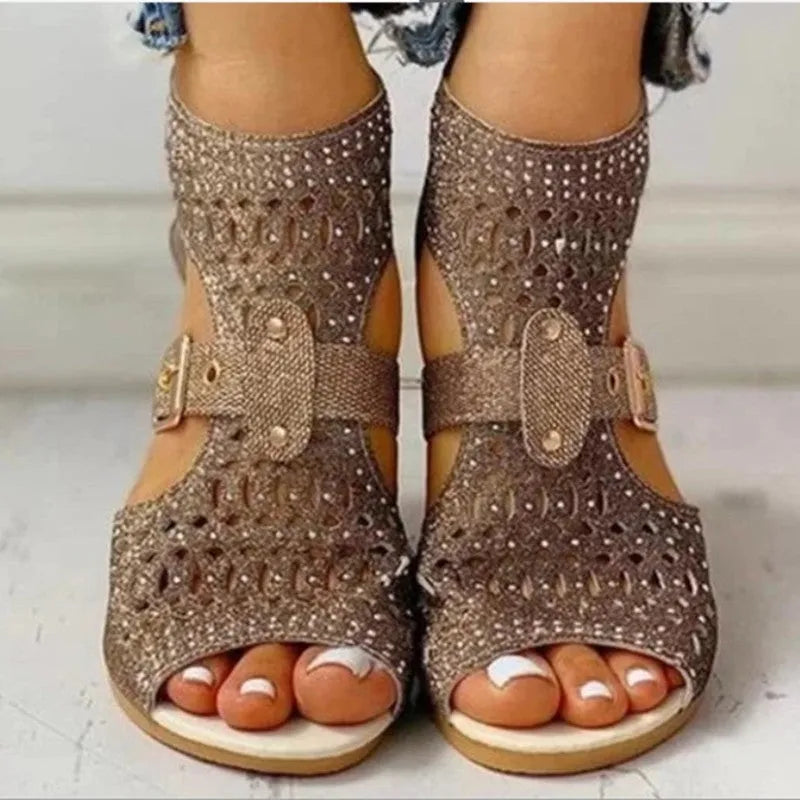 Women's beige flat sandals with back zipper and low wedge heel on a white background.