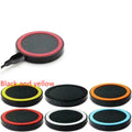 Compact round Qi wireless phone charger on a table in blue, next to a smartphone.