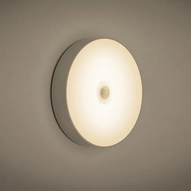 Small white circular motion sensing LED night light with USB charging port