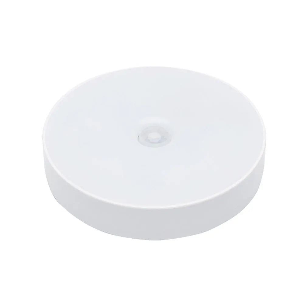 Small white circular motion sensing LED night light with USB charging port