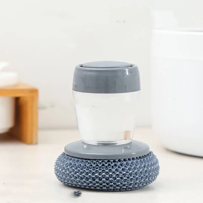 Kitchen palm brush with integrated push-type soap dispenser and bristles for scrubbing.