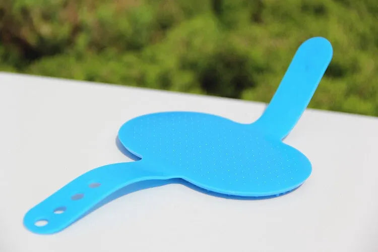 Oval rubber pet bath brush in hand for dog or cat grooming, red colour