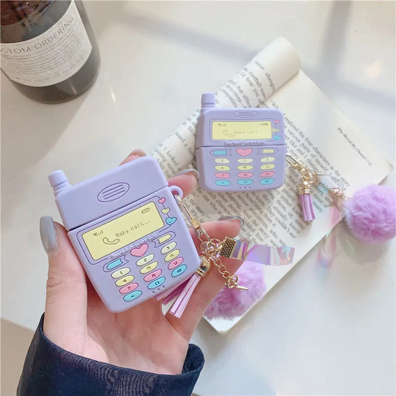 Purple silicone clamshell case for Apple AirPods with a small white fur ball pendant attached.