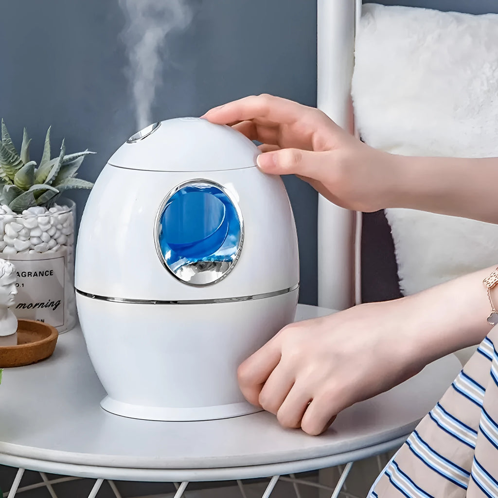 Compact round white USB desktop humidifier and aromatherapy diffuser on a wooden table.