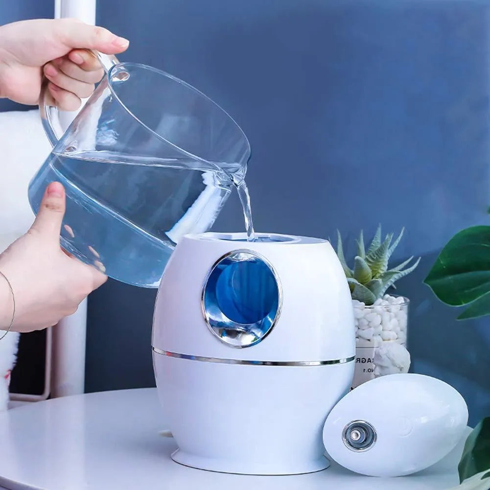 Compact round white USB desktop humidifier and aromatherapy diffuser on a wooden table.
