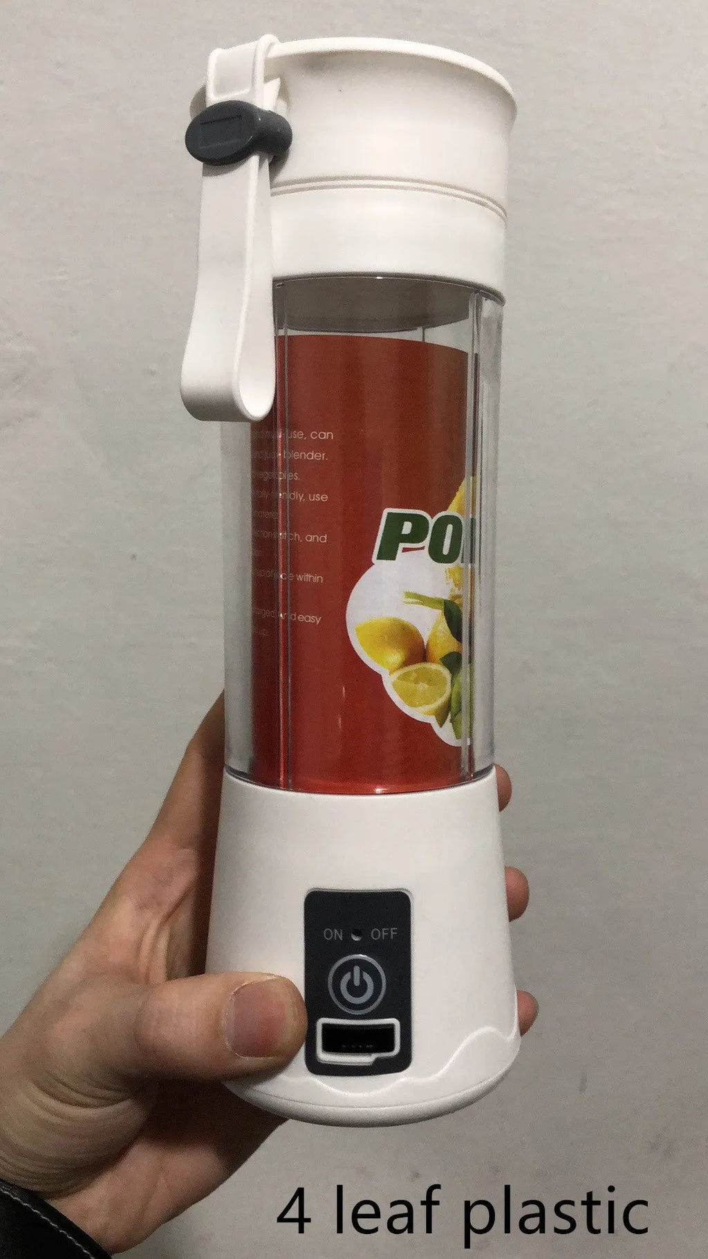 Mini USB electric fruit juicer with pink 400ml cup and stainless steel blades on a table.