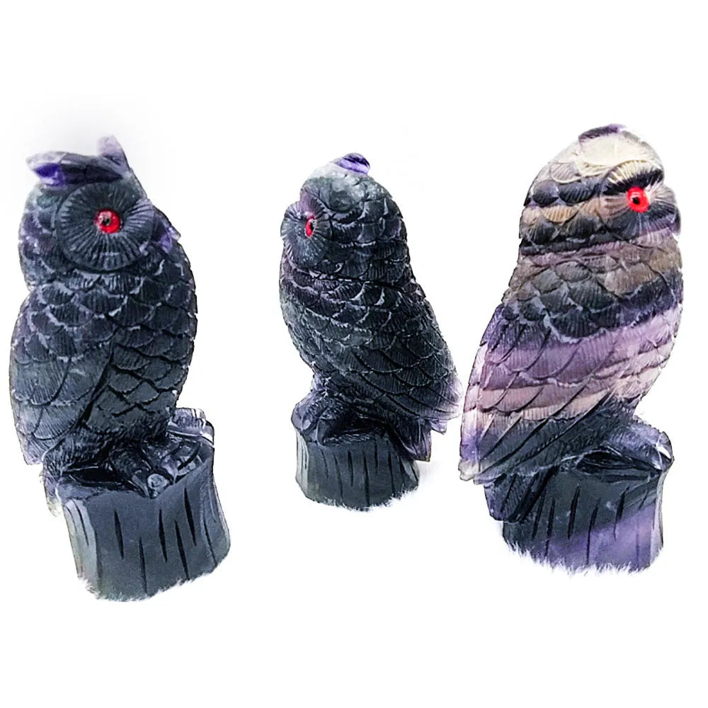 Purple fluorite hand-carved owl ornament on a wooden surface.