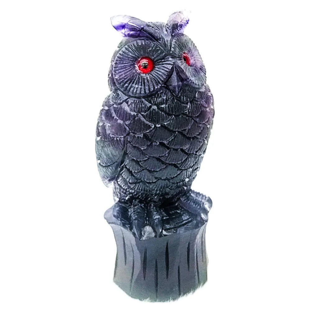 Purple fluorite hand-carved owl ornament on a wooden surface.