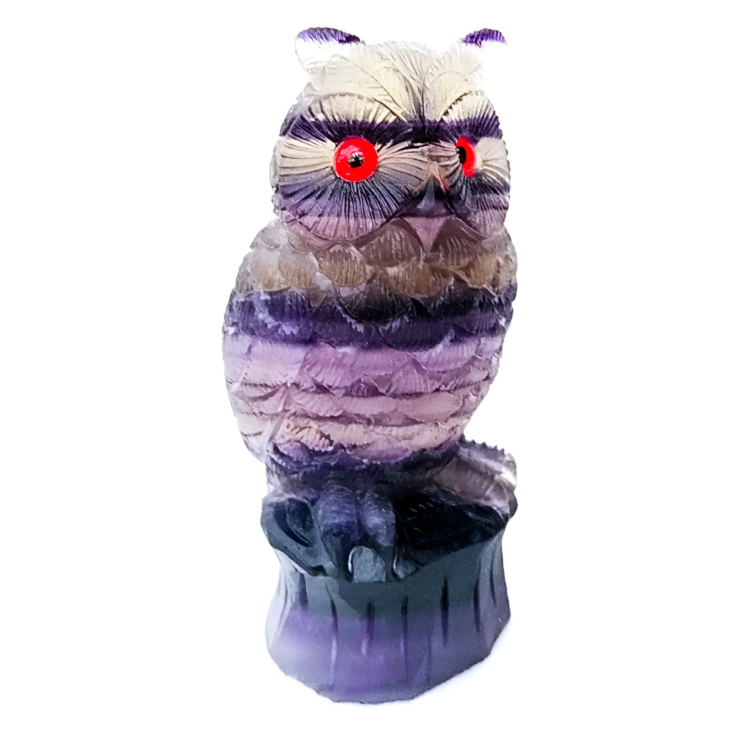 Purple fluorite hand-carved owl ornament on a wooden surface.