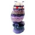 Purple fluorite hand-carved owl ornament on a wooden surface.