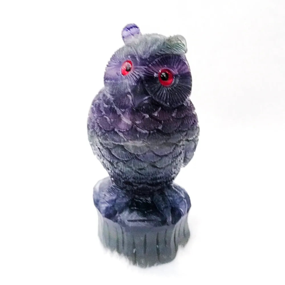 Purple fluorite hand-carved owl ornament on a wooden surface.