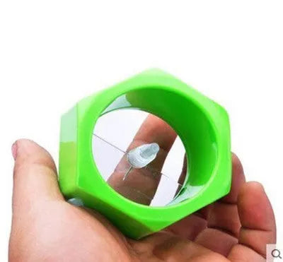 Yellow and green plastic spiral vegetable cutter for slicing cucumbers on a kitchen counter