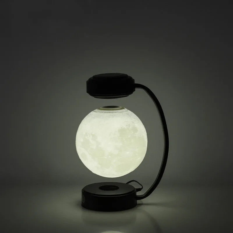 Black magnetic levitation moon lamp floating above base with touch control for bedside use