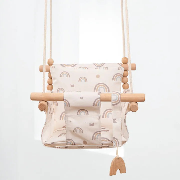 Natural cotton canvas baby swing chair with wooden seat and cushion hanging indoors