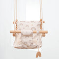 Natural cotton canvas baby swing chair with wooden seat and cushion hanging indoors