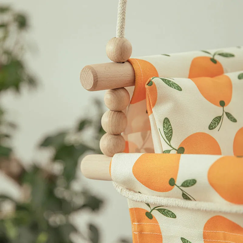 Natural cotton canvas baby swing chair with wooden seat and cushion hanging indoors