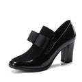 Women's black patent leather high-heel shoes with a thick heel and square toe.