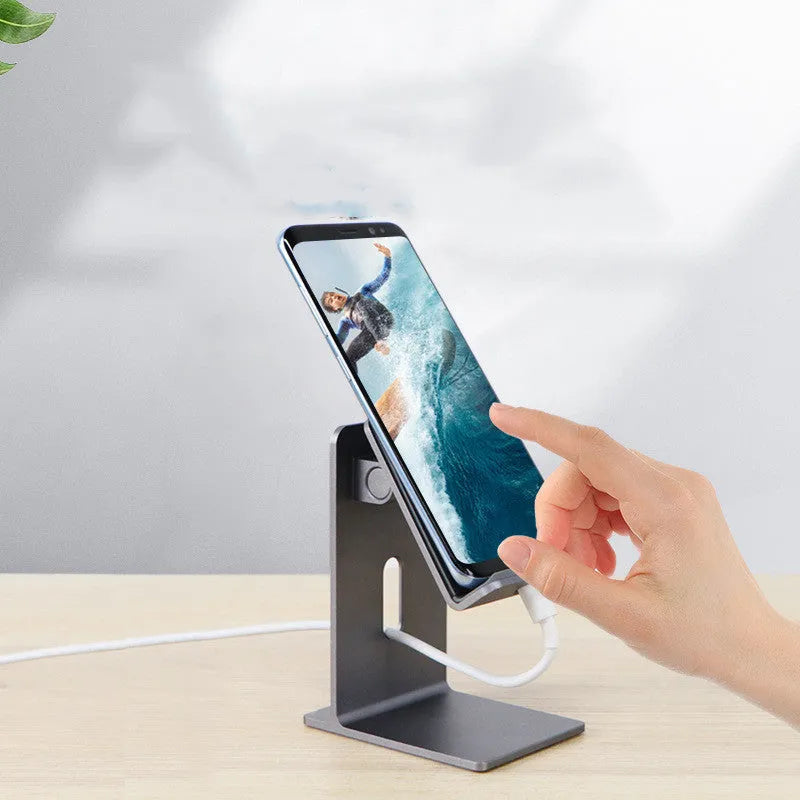 Dark space grey aluminium alloy mobile phone and tablet holder on a wooden desk.