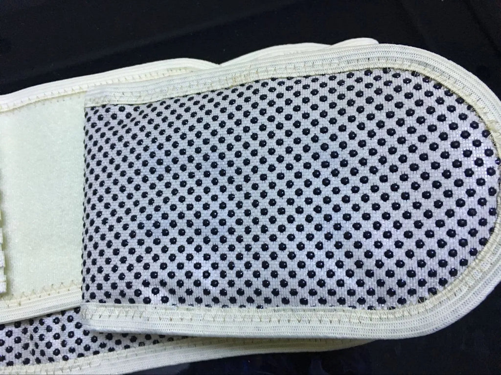 Black self-heating magnetic waist support belt for lumbar muscle strain on a white background.
