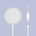 Silver metal Magsafe wireless charger for Apple iPhone on a table.