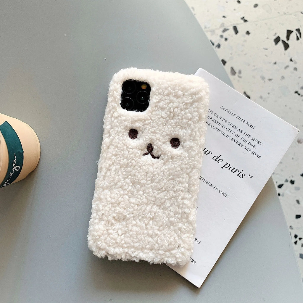Brown soft TPU iPhone case featuring a raised plush bear face with embroidered details.
