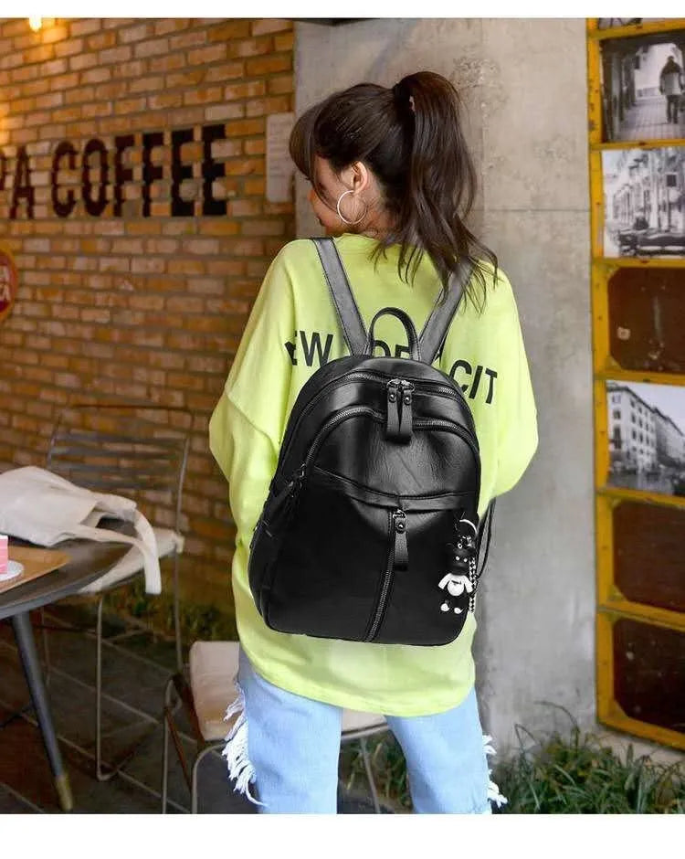 Black Pu leather backpack with soft surface, dual straps, and a large main compartment.