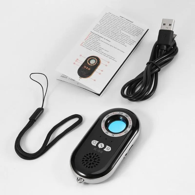 Compact black wireless signal detector with anti-theft alarm, shown next to a ruler for scale.