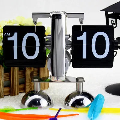 Small scale retro flip clock with black or white trim and black flip cards on a desk