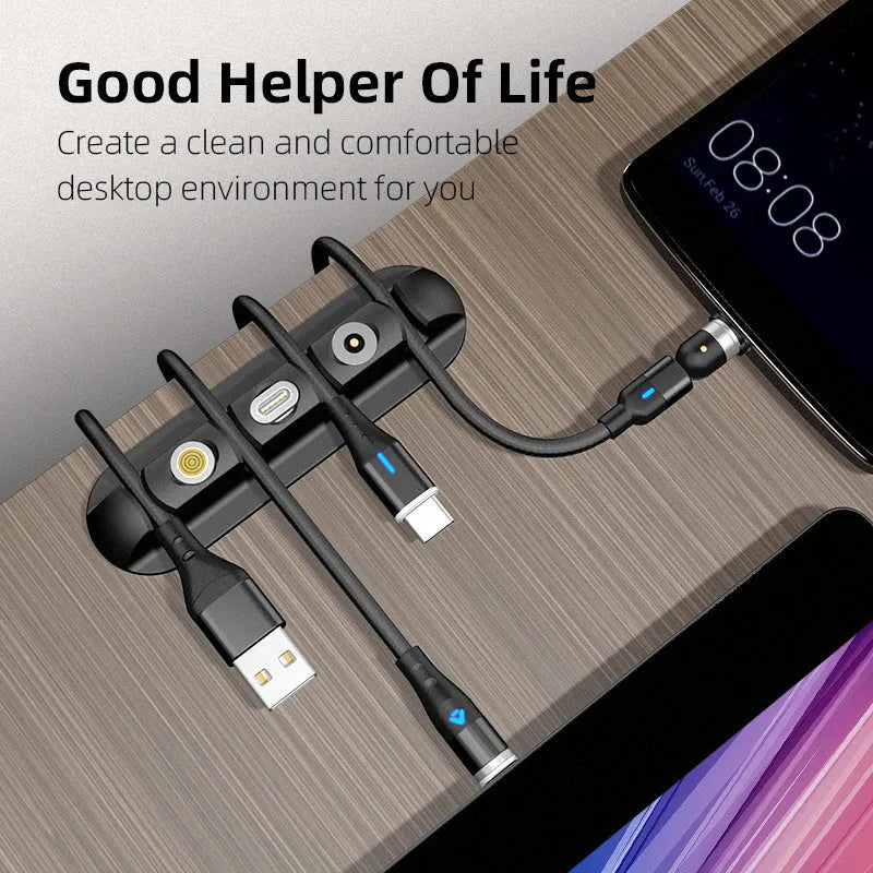Black soft plastic magnetic desktop charging cable organiser on a desk.