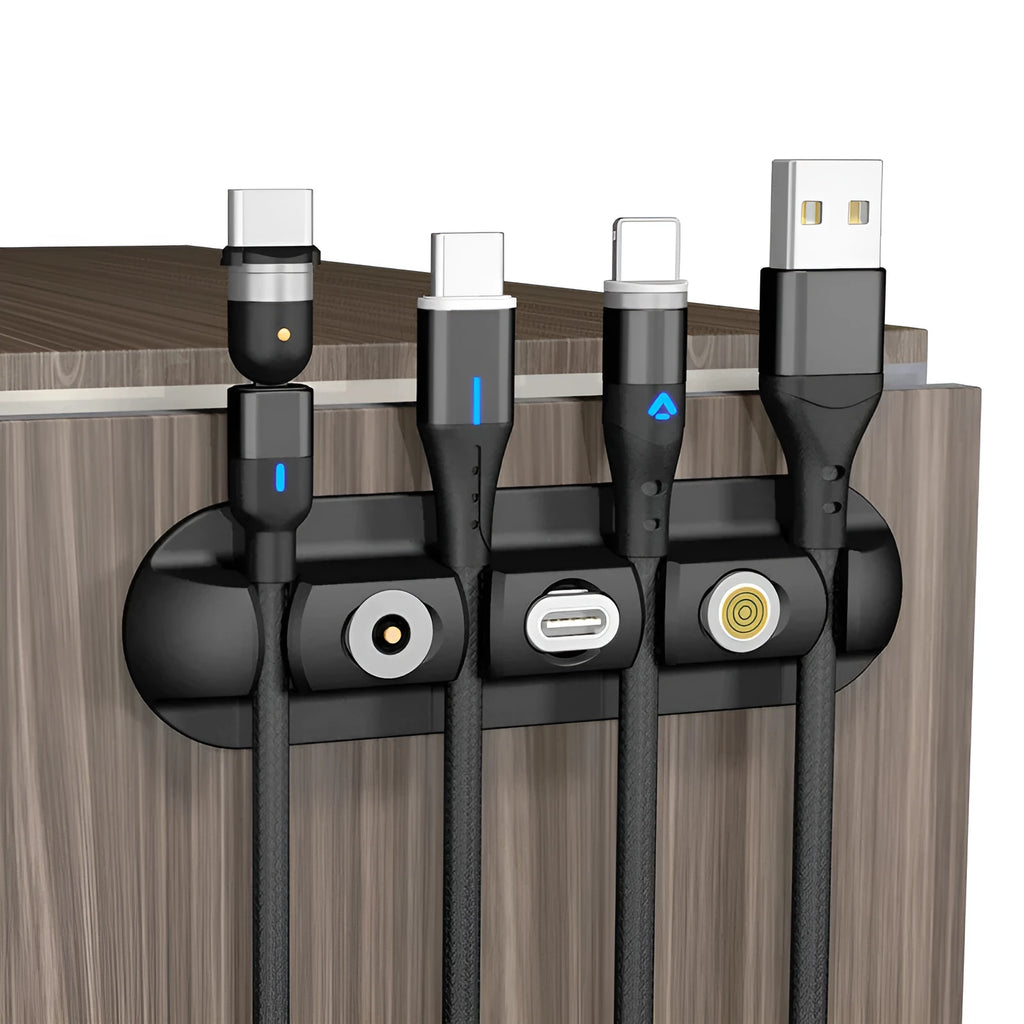Black soft plastic magnetic desktop charging cable organiser on a desk.