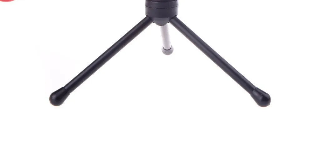 Black wired PC microphone with attached metal clip holder on a desk.