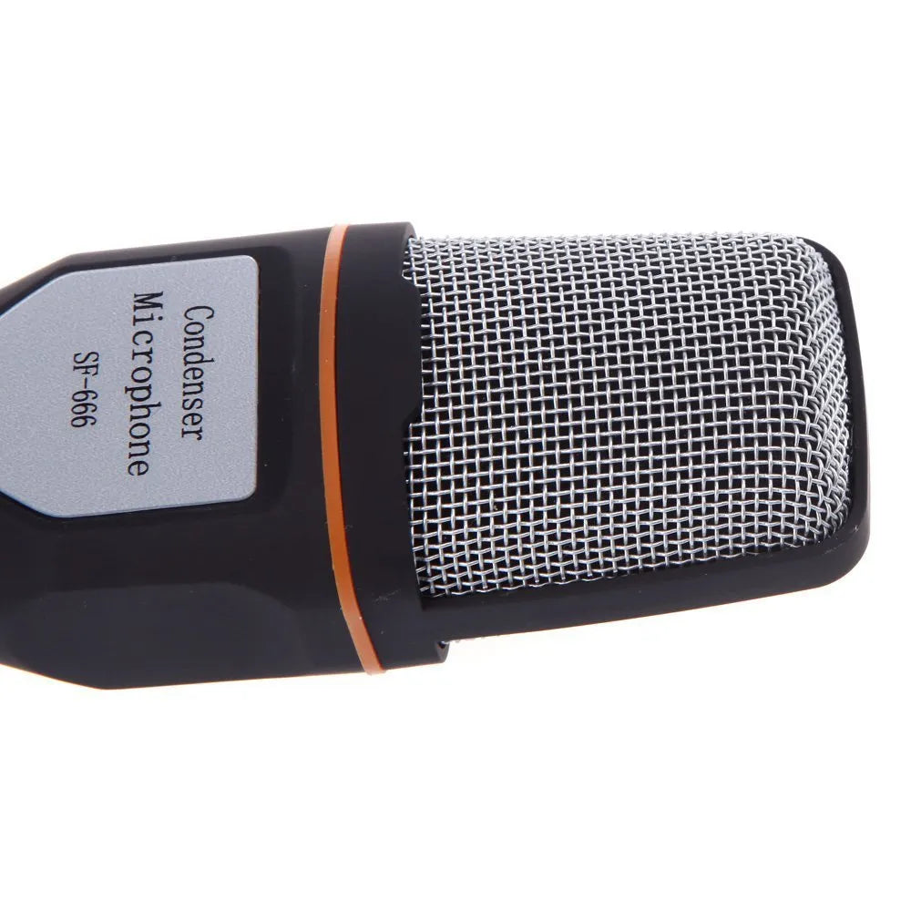 Black wired PC microphone with attached metal clip holder on a desk.
