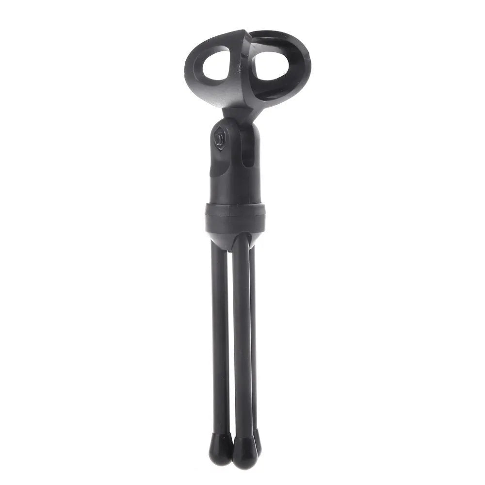 Black wired PC microphone with attached metal clip holder on a desk.
